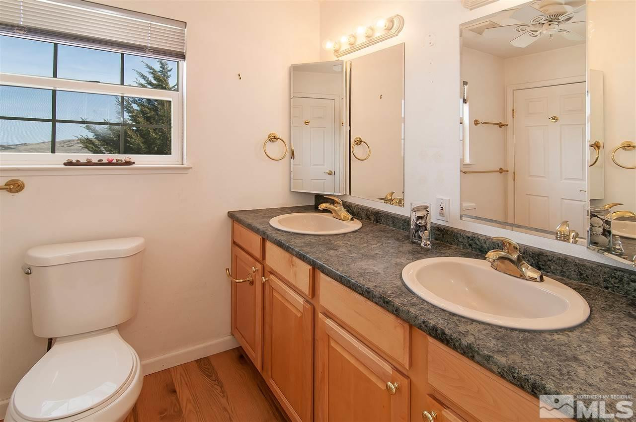 90 Bobcat Hill Road Reno, NV 89508 - Photo 14 of 24 a bathroom with a granite countertop toilet sink and mirror