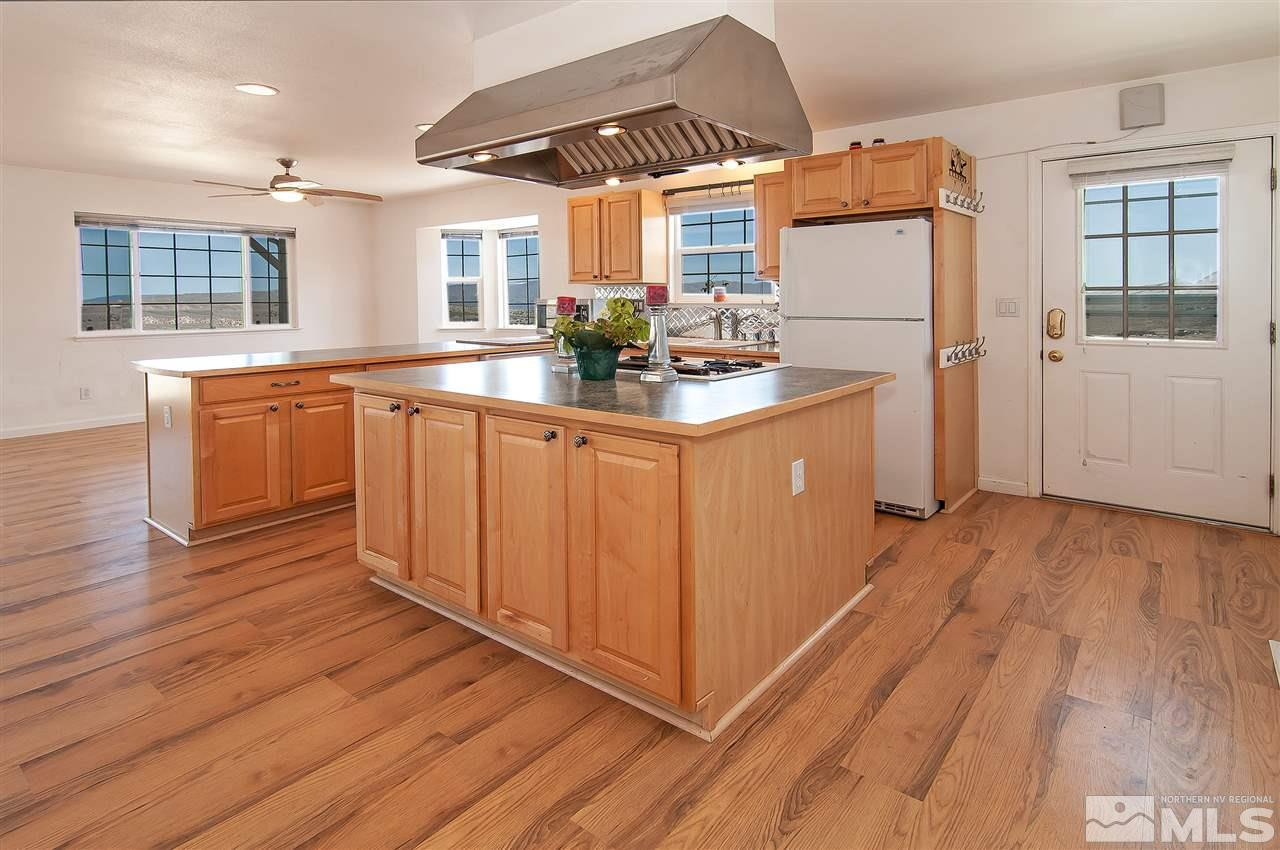 90 Bobcat Hill Road Reno, NV 89508 - Photo 9 of 24 a kitchen with stainless steel appliances granite countertop a refrigerator a sink dishwasher a stove and white countertops with wooden floor