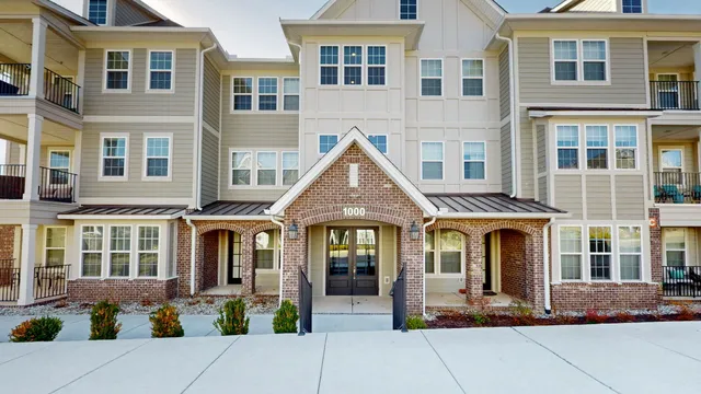 a front view of a residential apartment building with a yard