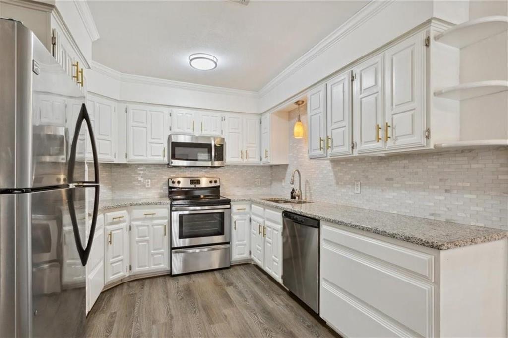 2306 Melissa Drive Waco, TX 76708 - Photo 9 of 22 a kitchen with a sink a microwave a refrigerator and cabinets