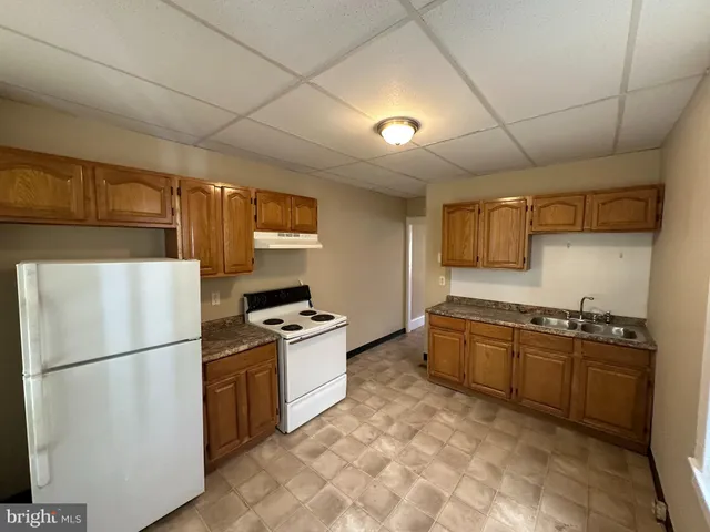 a kitchen with stainless steel appliances granite countertop a refrigerator a stove a sink dishwasher and a refrigerator