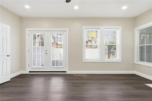 an empty room with wooden floor and windows