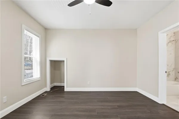 an empty room with wooden floor and windows
