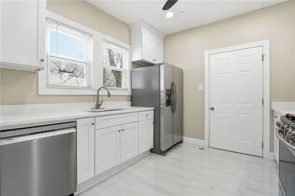 a kitchen with stainless steel appliances a refrigerator sink and cabinets