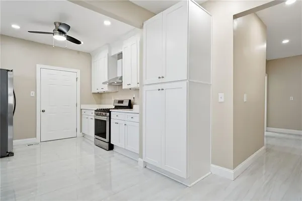 a kitchen with white cabinets and white appliances