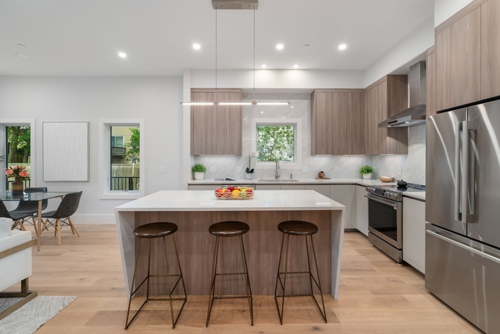 2202 Commonwealth Avenue, Unit 2 Newton, MA 02466 - Photo 1 of 23 a kitchen with kitchen island a sink table and chairs