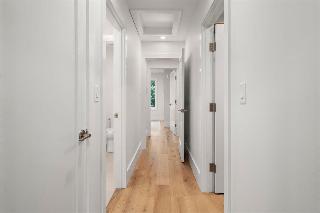 2202 Commonwealth Avenue, Unit 2 Newton, MA 02466 - Photo 21 of 23 a view of a hallway with wooden floor and a bathroom
