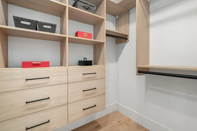 a utility room with closet and wooden floor
