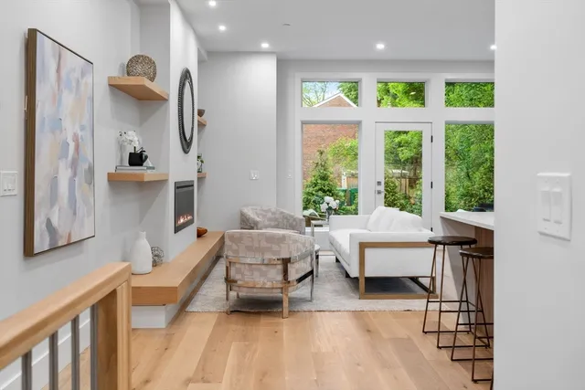 a living room with furniture a window and wooden floor