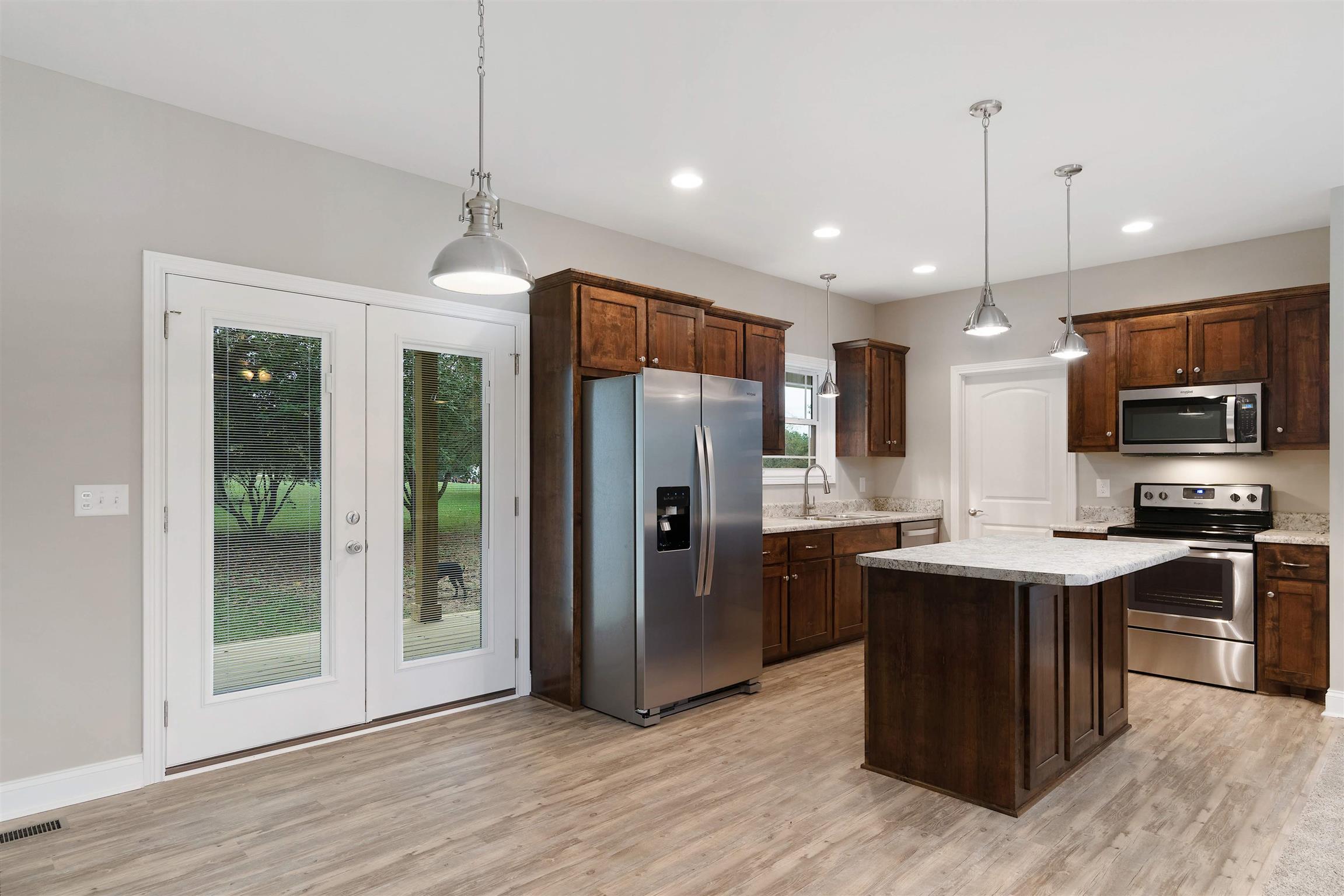 4760 Somerville Road Cross Plains, TN 37049 - Photo 11 of 30 a kitchen with stainless steel appliances granite countertop a refrigerator a sink a stove a microwave and wooden floor