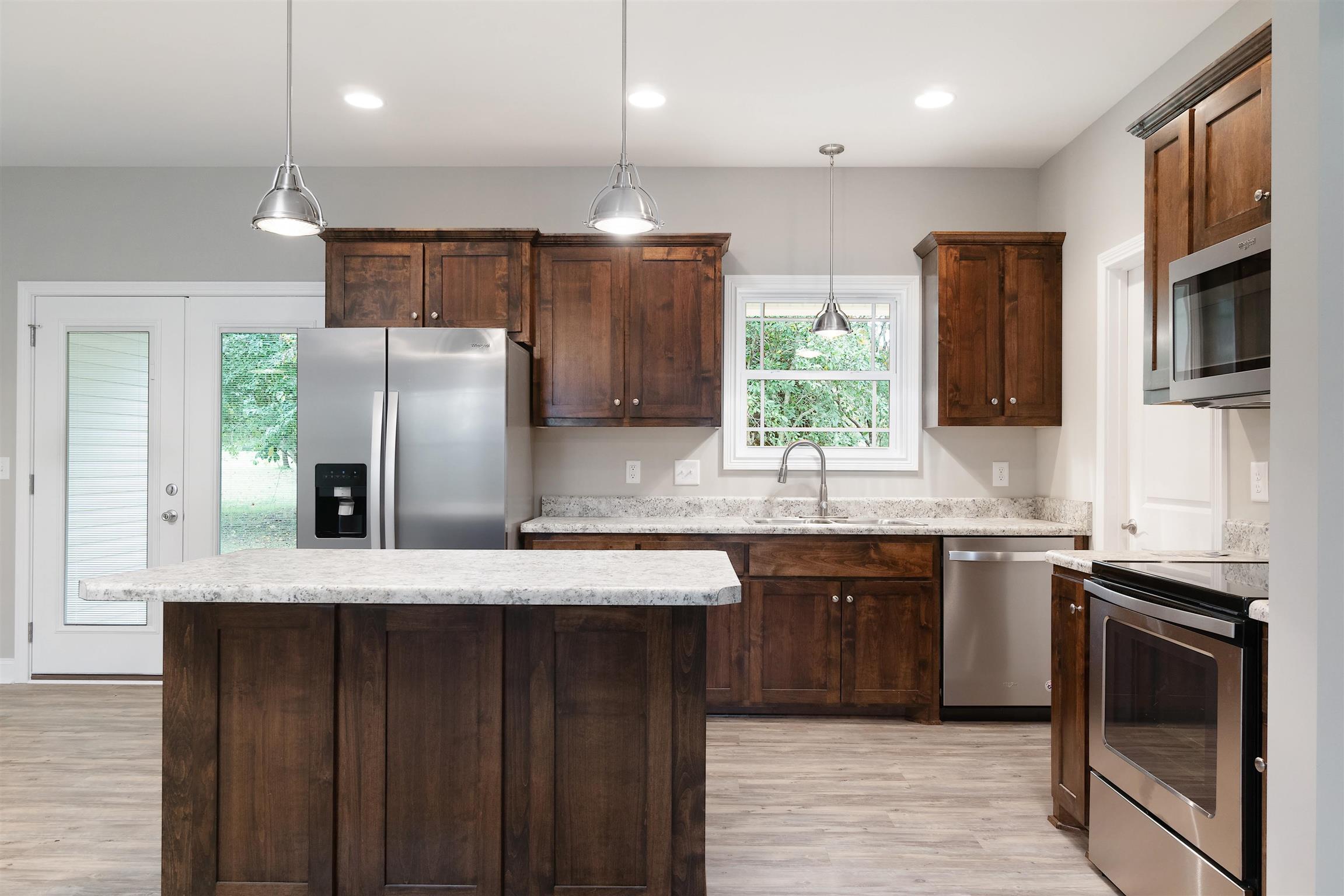4760 Somerville Road Cross Plains, TN 37049 - Photo 17 of 30 a kitchen with stainless steel appliances granite countertop a refrigerator a sink a stove a microwave and wooden cabinets