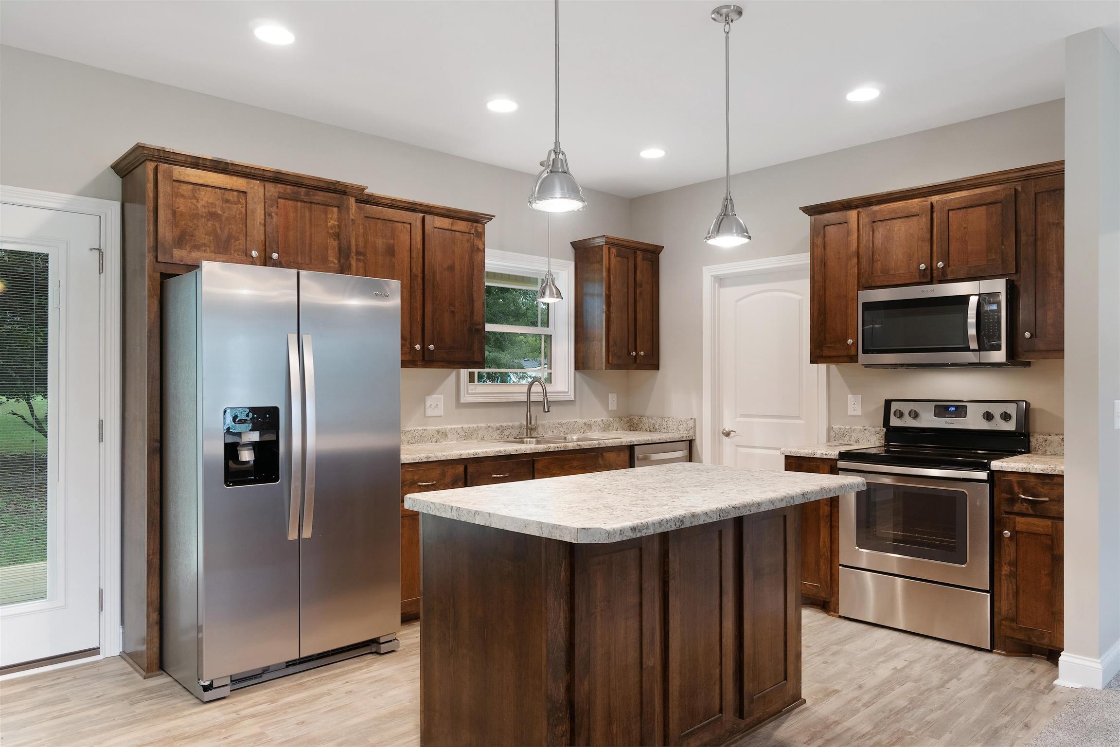 4760 Somerville Road Cross Plains, TN 37049 - Photo 10 of 30 a kitchen with stainless steel appliances granite countertop a refrigerator a sink a stove top oven and a refrigerator with wooden floor
