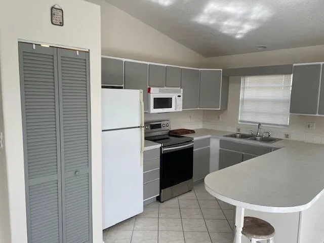 a kitchen with stainless steel appliances granite countertop a sink a stove a refrigerator and a refrigerator