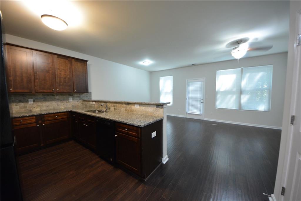5873 Taka Lane Lithonia, GA 30038 - Photo 7 of 26 a kitchen with wooden floors and wooden cabinets