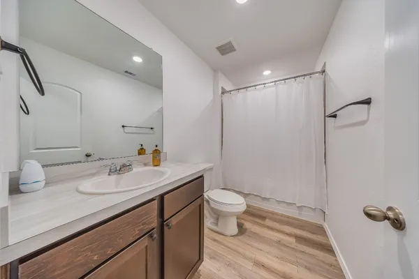 a bathroom with a sink toilet a mirror and shower