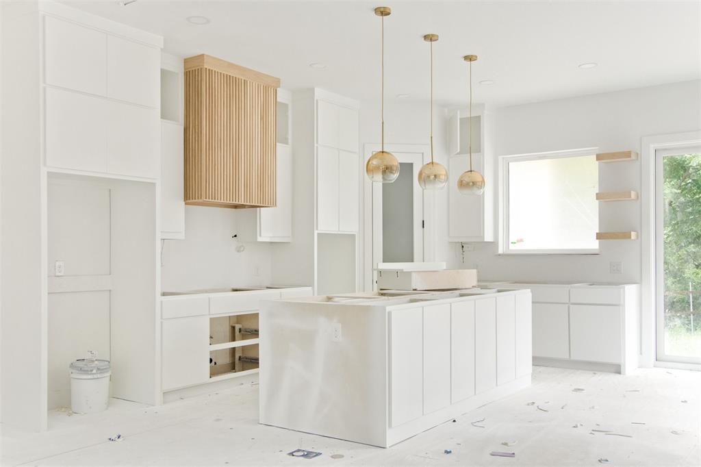 a bathroom with white cabinets and a wooden floor