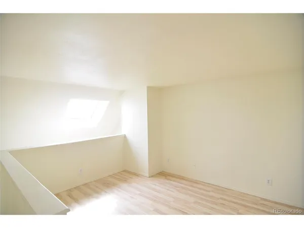 a view of an empty room and wooden floor