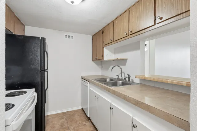 a kitchen with a sink and a refrigerator