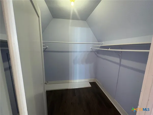 a view of walk in closet with empty racks