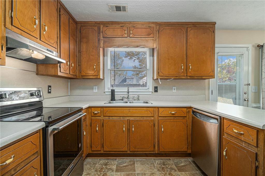 40 Willow Tree Terrace Covington, GA 30016 - Photo 11 of 32 a kitchen with stainless steel appliances granite countertop a sink stove and cabinets