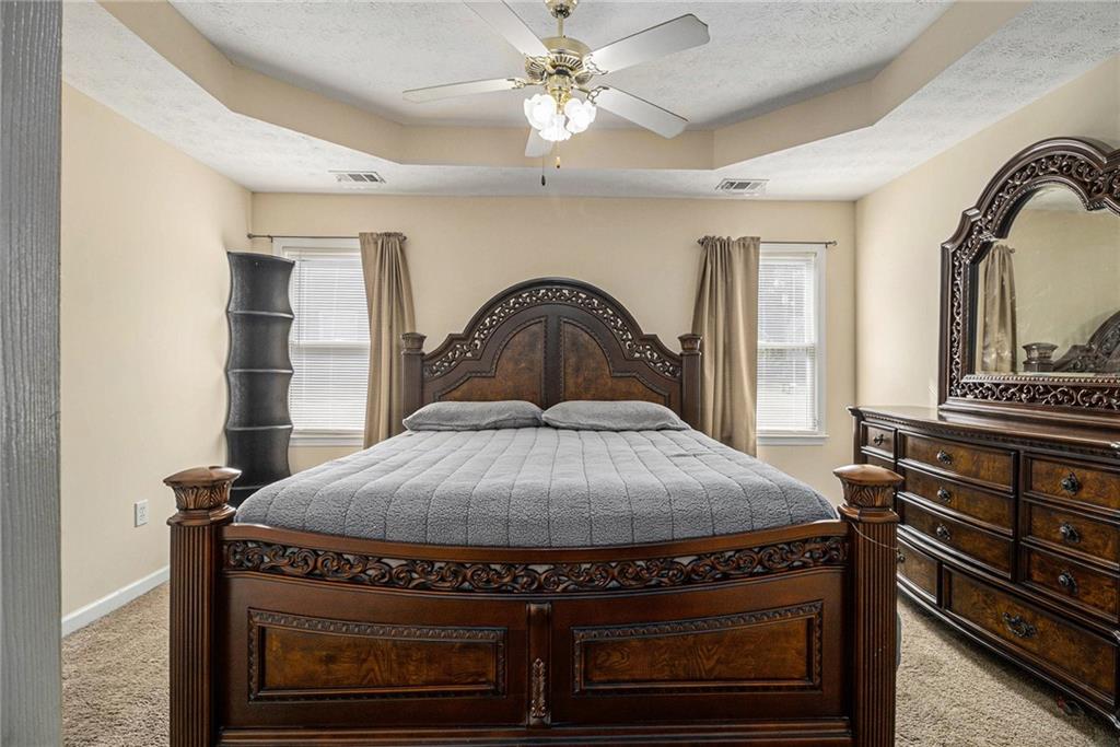 40 Willow Tree Terrace Covington, GA 30016 - Photo 13 of 32 a bedroom with a bed and dresser with mirror