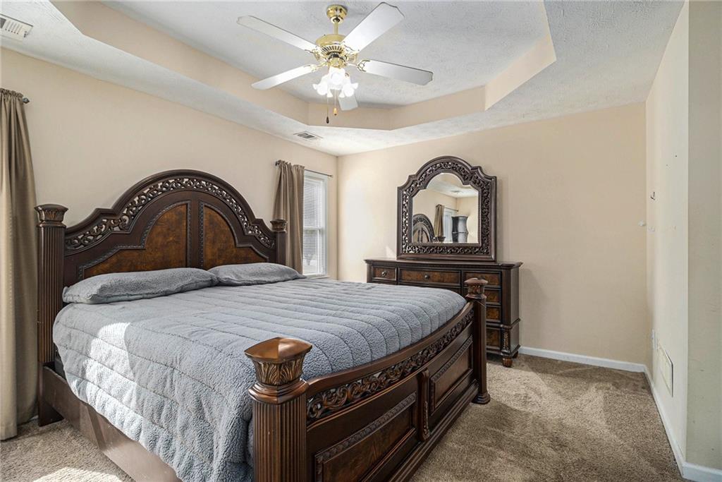 40 Willow Tree Terrace Covington, GA 30016 - Photo 14 of 32 a bedroom with a bed and a chandelier