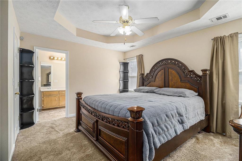 40 Willow Tree Terrace Covington, GA 30016 - Photo 15 of 32 a spacious bedroom with a bed and a chandelier