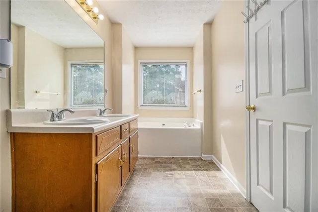a bathroom with a tub sink and mirror