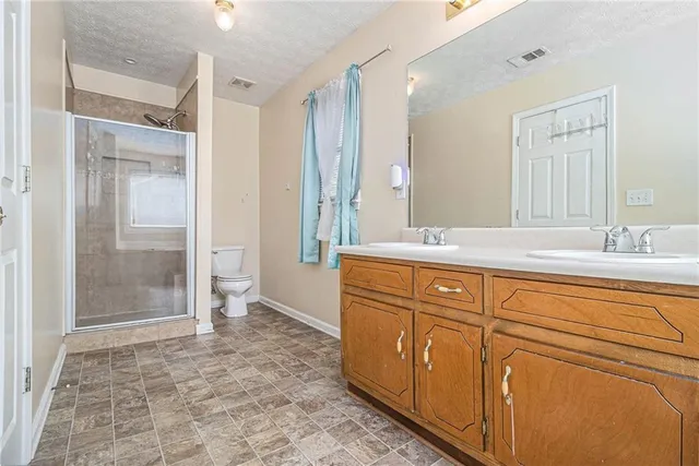 a spacious bathroom with a granite countertop sink mirror and shower