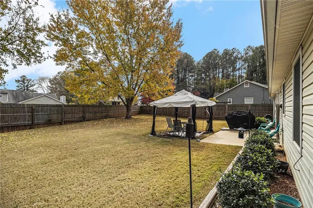 a view of a backyard with table and chairs under an umbrella