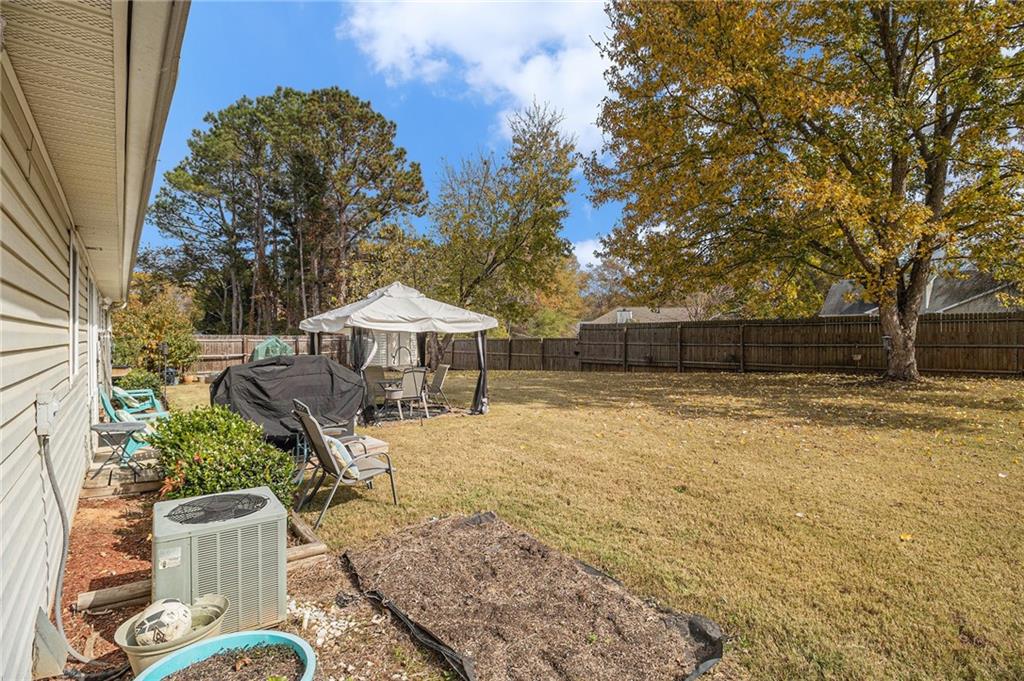 40 Willow Tree Terrace Covington, GA 30016 - Photo 28 of 32 a view of a backyard with table and chairs under an umbrella