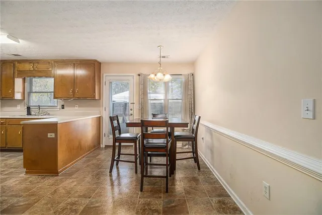 a kitchen with a table chairs sink and cabinets