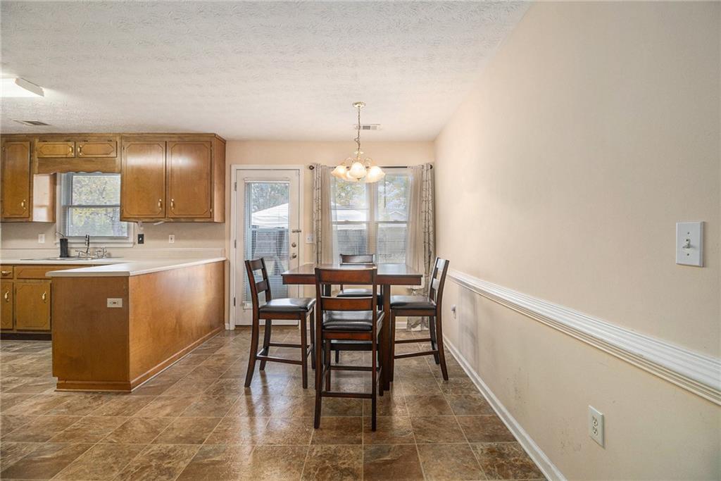 40 Willow Tree Terrace Covington, GA 30016 - Photo 9 of 32 a kitchen with a table chairs sink and cabinets