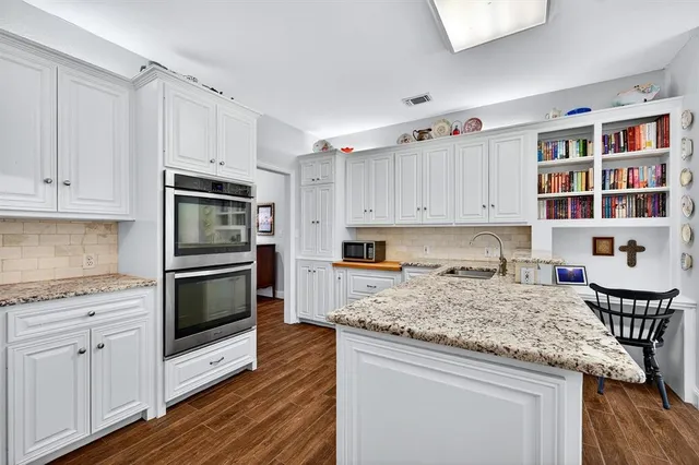 a kitchen with granite countertop white cabinets and appliances