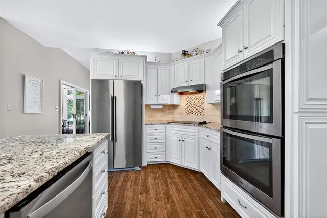 a kitchen with granite countertop stainless steel appliances and wooden cabinets