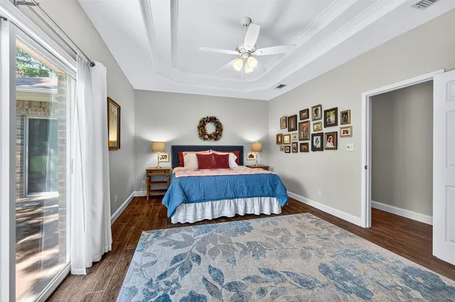 a bedroom with a large bed a chandelier and dresser