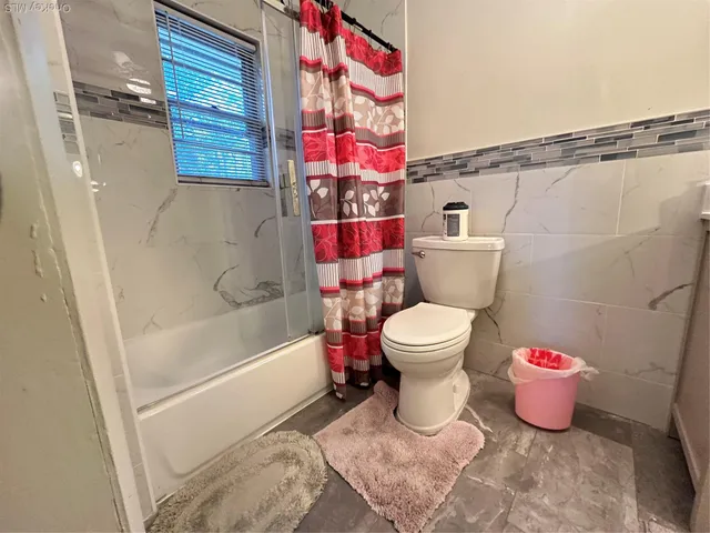 a bathroom with a toilet and a shower