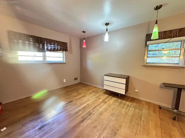 a room with a wooden floor and a window