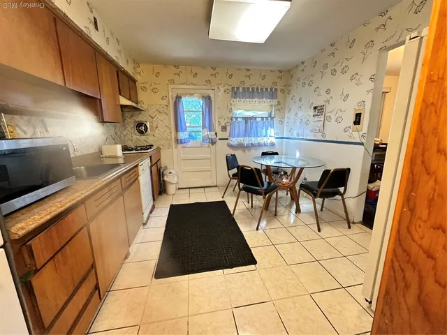 a kitchen with stainless steel appliances a refrigerator a sink a stove and white cabinets