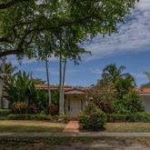a view of a house with a yard and potted plants