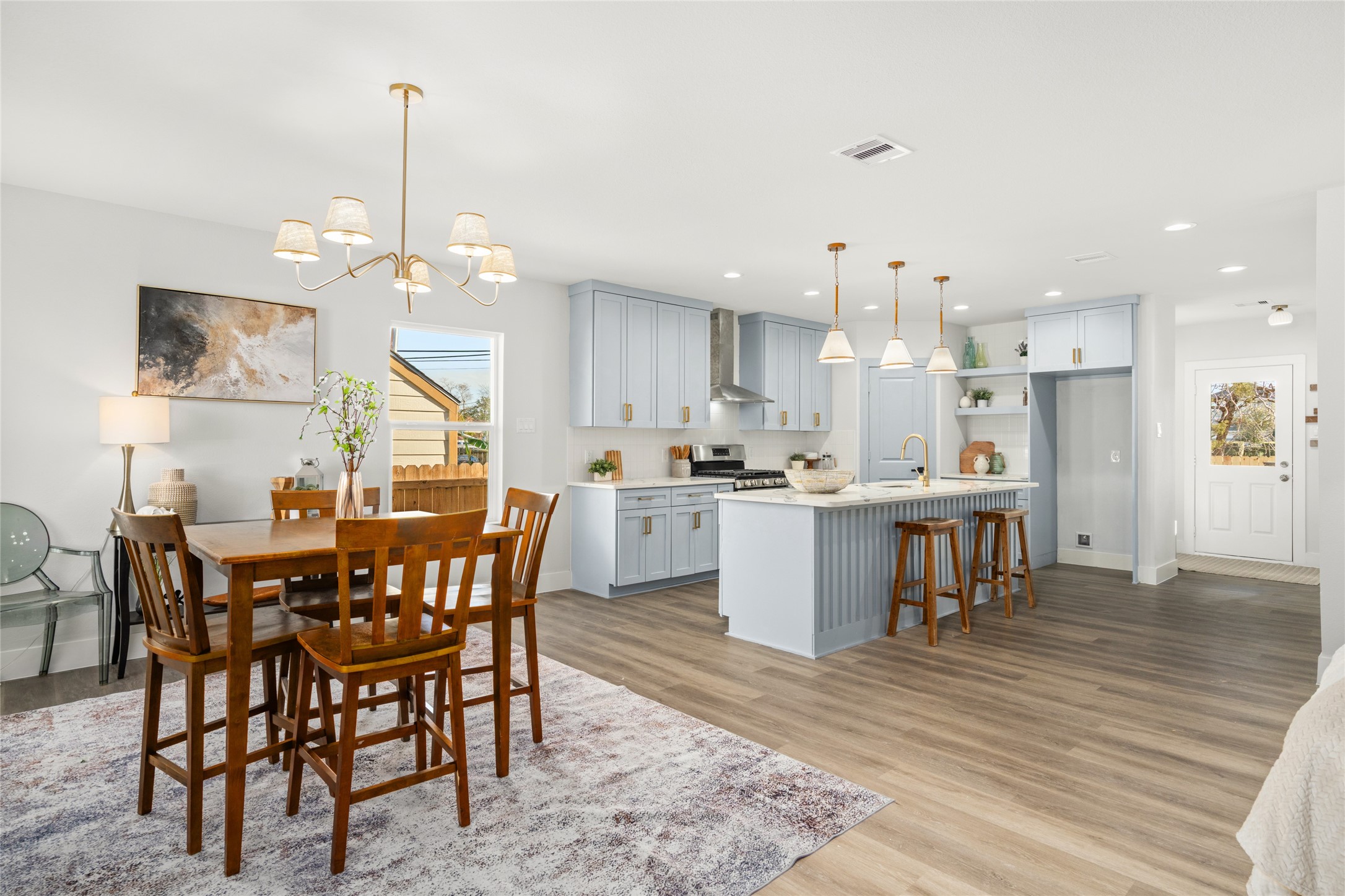 5420 Pease Street Houston, TX 77023 - Photo 17 of 43 a view of a dining room and livingroom with furniture wooden floor a chandelier