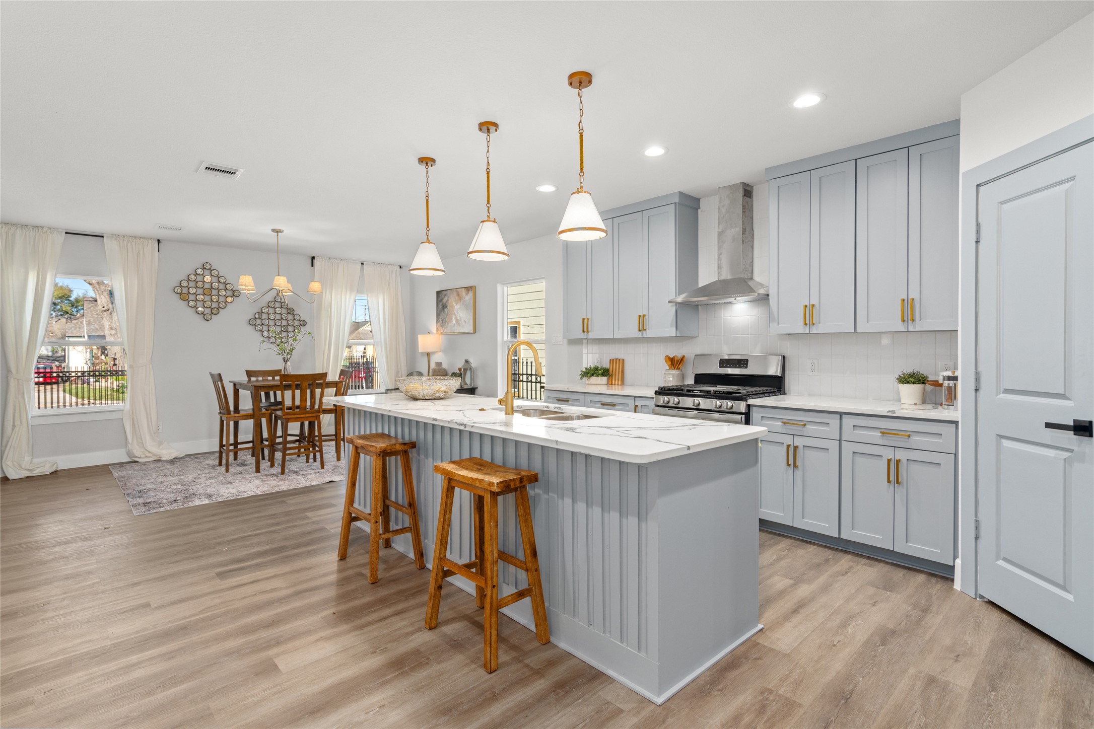 5420 Pease Street Houston, TX 77023 - Photo 5 of 43 a kitchen with stainless steel appliances kitchen island granite countertop a stove a sink a refrigerator and white cabinets with wooden floor