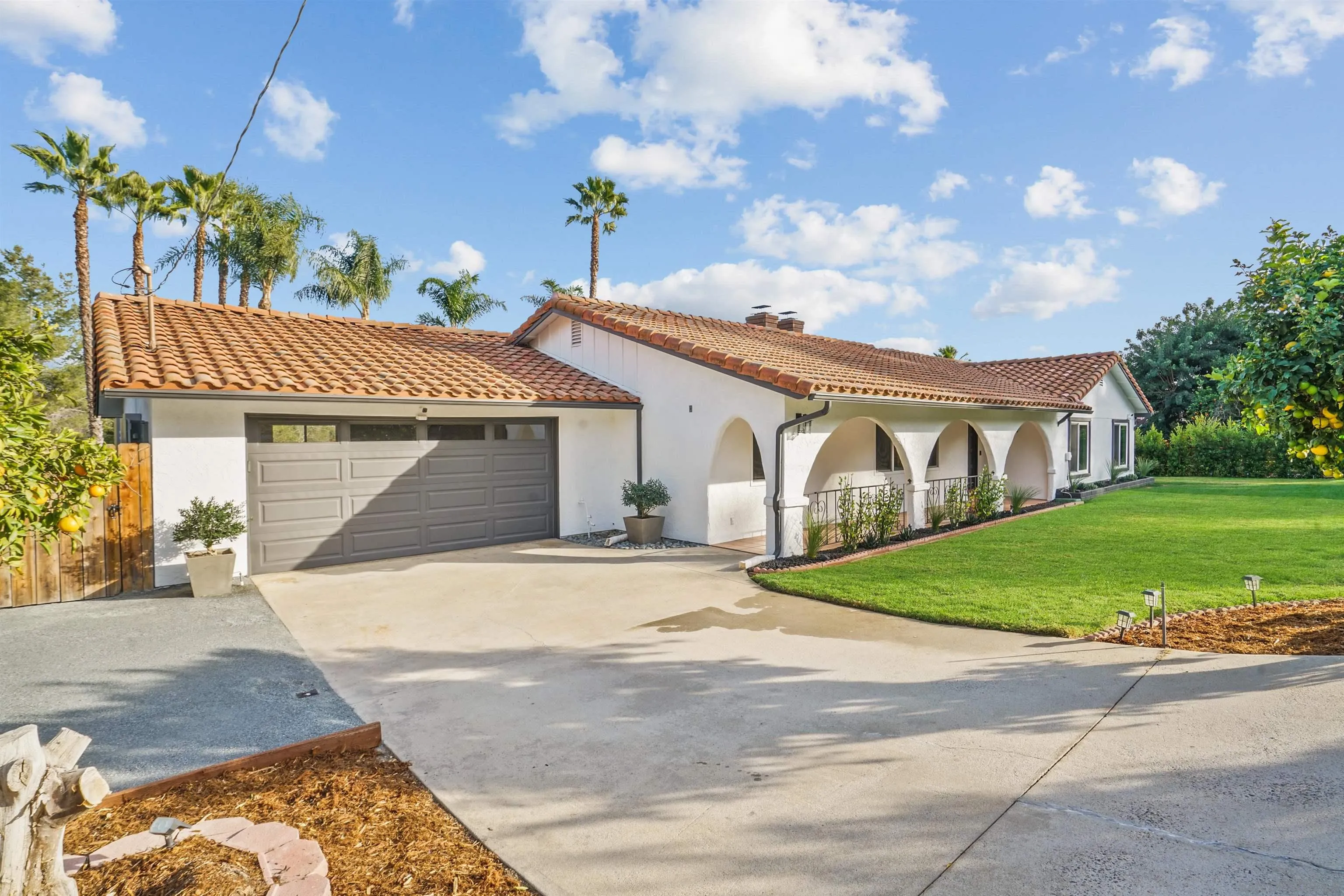 174 Vía De Casa Fallbrook, CA 92028 - Photo 2 of 47 a front view of a house with a garden and plants