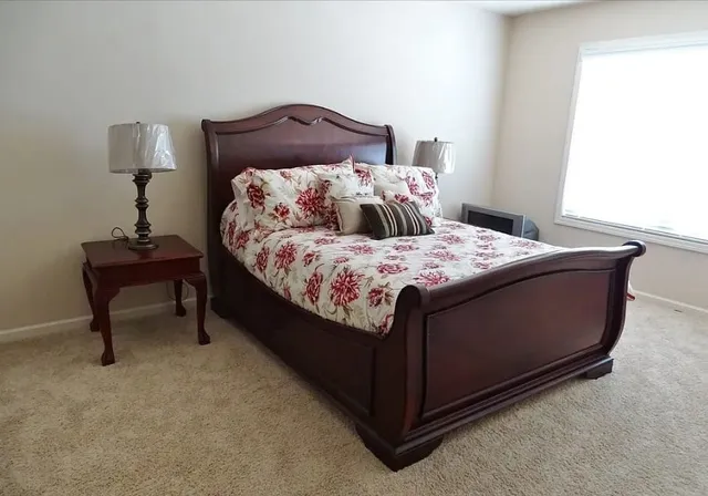 a bed sitting in a bedroom next to a lamp