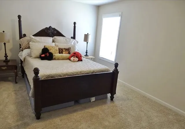 a bed sitting in a bedroom next to a window