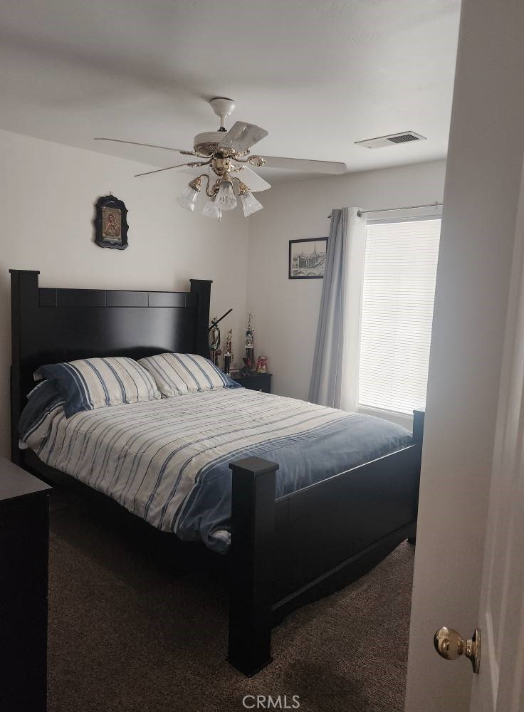 5348 Gatson Street Bakersfield, CA 93314 - Photo 11 of 33 a bedroom with a bed and a chandelier