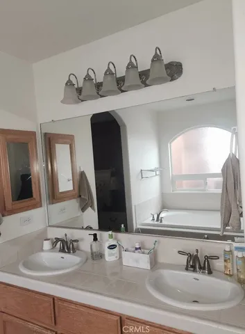a bathroom with double vanity sinks and a mirror