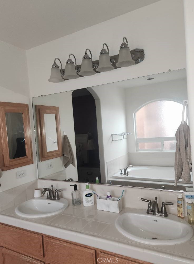 5348 Gatson Street Bakersfield, CA 93314 - Photo 14 of 33 a bathroom with double vanity sinks and a mirror