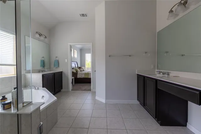 a bathroom with a sink vanity and tub