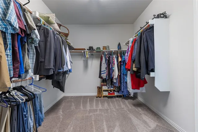 a view of walk in closet with clothes